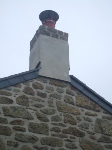 Lime render to stabilize and waterproof and old chimney. Extra courses of Portuguese granite added.