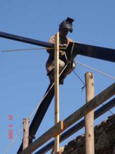 The local welder doing a wonderful job welding up the roof steels